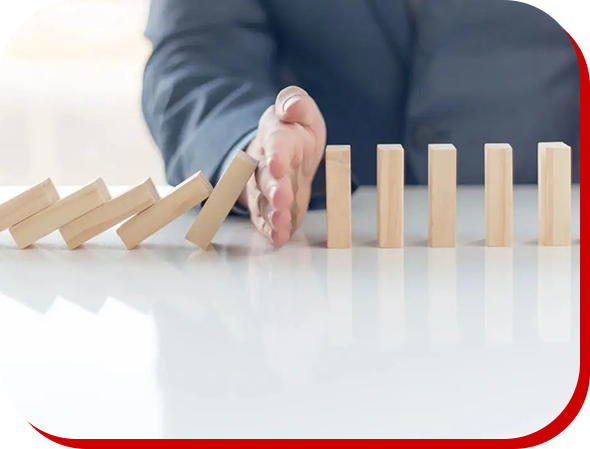 A person stopping the domino effect on a table.